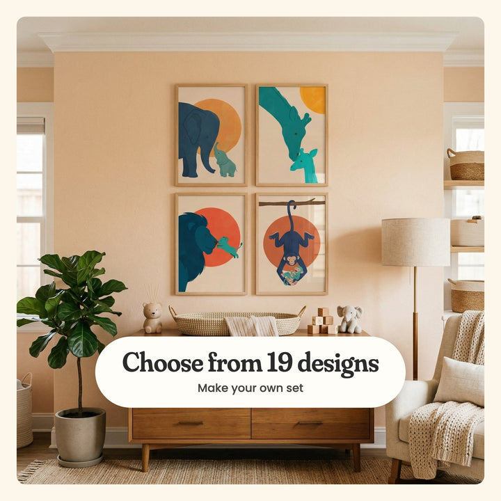Nursery with a peach wall and four safari family prints in light wood frames above a walnut dresser with a woven basket and a knit elephant, beside a fiddle leaf fig and an armchair: an elephant and calf, a giraffe nuzzling its calf, a lion cub leaping up to its dad and a monkey hanging from a branch with its baby, labeled Choose from 19 designs, Make your own set