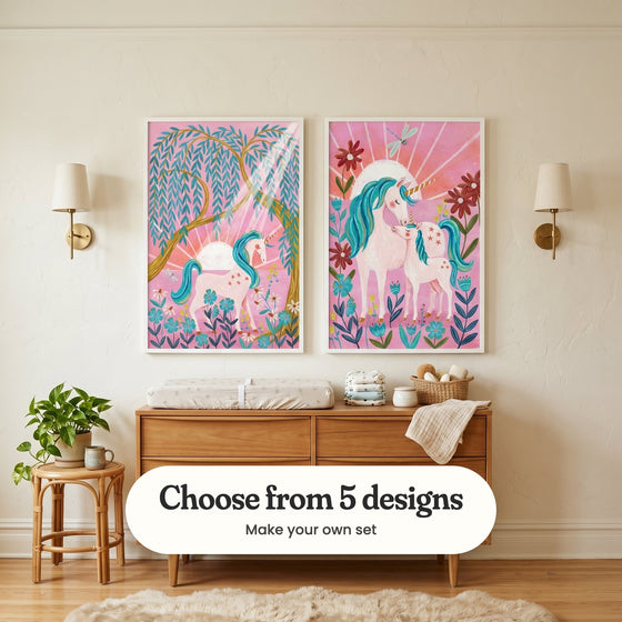 Cream nursery with two unicorn prints in white frames above a wood changing dresser with a changing pad and a woven basket, between two brass wall lamps, beside a rattan stool with a plant and a sheepskin rug: Golden Willow Unicorn and Magical Unicorn Duo, with a label reading Choose from 5 designs, Make your own set
