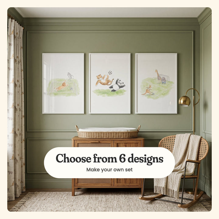 Sage panelled nursery wall with three safari animal soccer prints in white frames above a wood dresser with a woven changing basket, beside a rattan rocking chair and a brass floor lamp: a lion goalkeeper diving, a tiger's bicycle kick over a panda and a kangaroo shooting at goal, labeled Choose from 6 designs, Make your own set