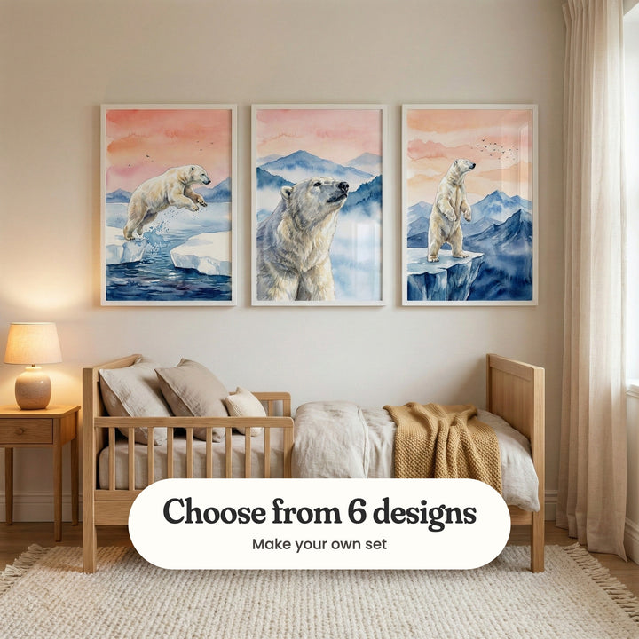 Nursery with three polar bear prints in white frames above a light wood toddler bed with a mustard knit throw, beside a bedside table and lamp: Arctic Leap, Arctic Mist Gaze and Arctic Sunset Sentinel, with a label reading Choose from 6 designs, Make your own set