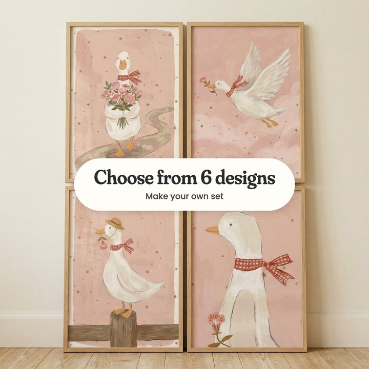 Four goose prints in light wood frames leaning against a cream wall on a wood floor: a goose carrying a bouquet down a winding path, a goose flying through pink clouds, a goose in a straw hat on a fence post and a close-up goose with a red gingham bow, with a label reading Choose from 6 designs, Make your own set