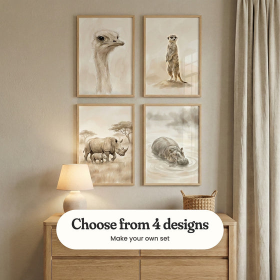 Warm beige room with four animal prints in light wood frames in two rows above a light wood dresser with a table lamp and a woven basket, beside a linen curtain: Elegant Ostrich Gaze, Desert Sentry, Savanna Rhino Duo and Gentle River Giant, with a label reading Choose from 4 designs, Make your own set