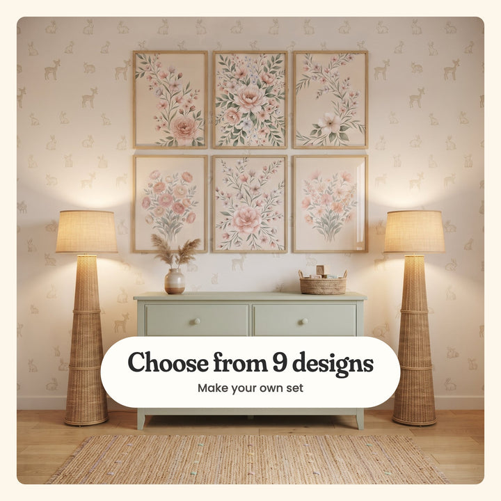 Nursery with six floral prints in light wood frames in two rows on bunny-and-fawn wallpaper, above a sage dresser between two rattan floor lamps: blossom stems with a pink peony, a full bouquet with a blush peony, blossom stems with one large white bloom, a bouquet of peach and blush ranunculus, blossom sprays around a full blush rose and a loose bouquet of peach and blush wildflowers, labeled Choose from 9 designs, Make your own set