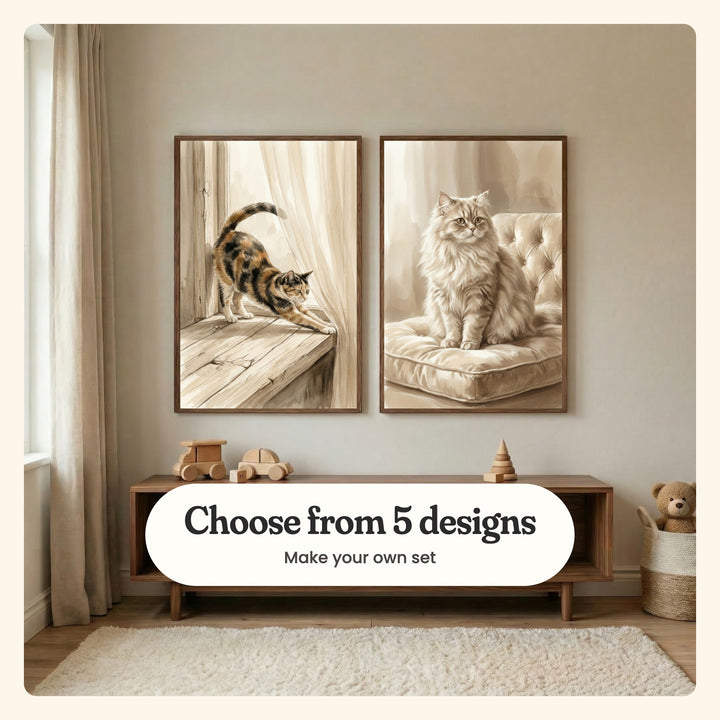 Cream wall with two cat prints in dark wood frames above a low walnut console with wooden toy cars, beside a basket with a teddy bear: Morning Sun Stretch and Golden Feline Grace, labeled Choose from 5 designs, Make your own set