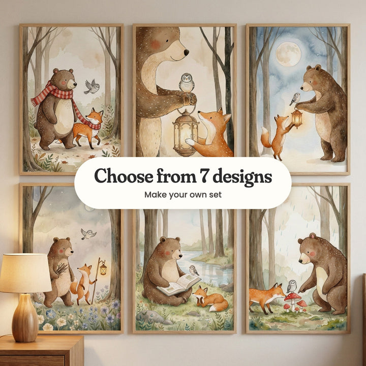 Six bear and fox prints in light wood frames in two rows, with a lamp on a wood dresser at the lower left: the pair walking in red scarves, the bear holding a lantern with an owl on it, the bear handing the fox a lantern under a full moon, the bear carrying sticks beside the fox with a lantern, the bear reading by a river and the pair by red mushrooms in the rain, with a label reading Choose from 7 designs, Make your own set
