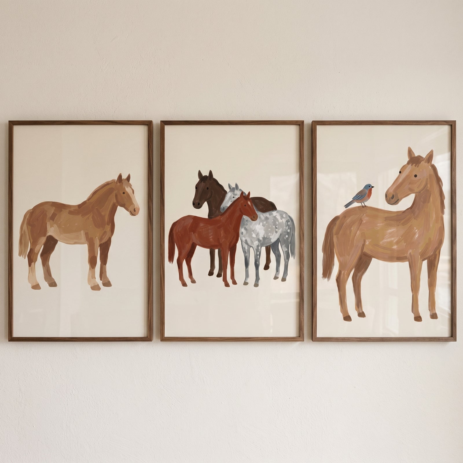 Warm earth tone horse print set of 3 features horses in brown and grey, including one with a small bird, in wood frames.