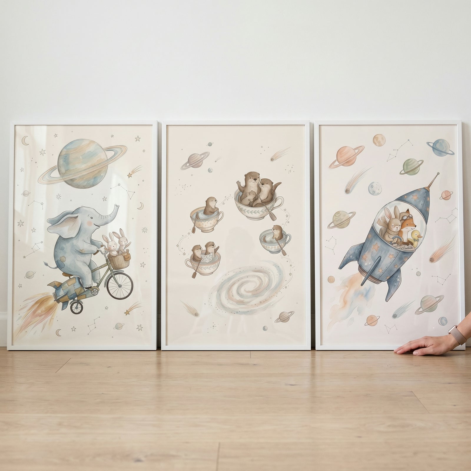 Watercolor astral voyage animals wall art set of 3 depicts an elephant on a bike, otters in teacups, and a fox in a rocket.