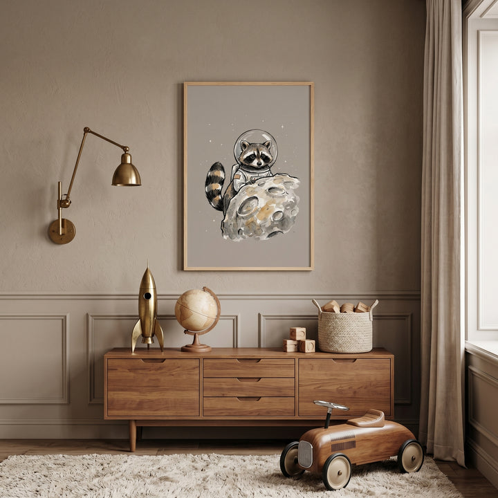 Watercolor astronaut suit raccoon wall art hangs above a wooden dresser in a nursery with a toy car and rocket model.