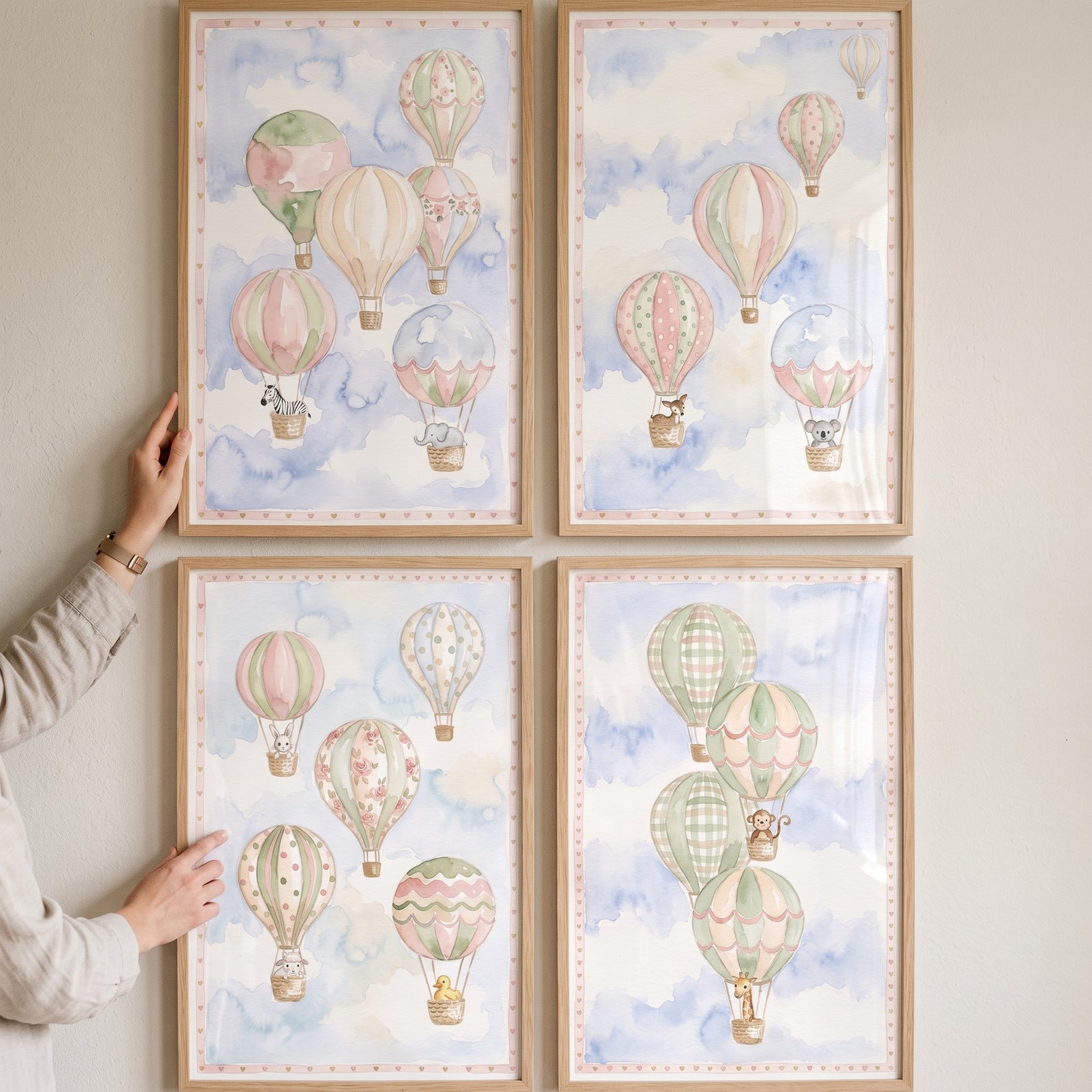 Watercolor baby animal balloon wall art set of 4 features cute creatures in hot air balloons among soft blue clouds.