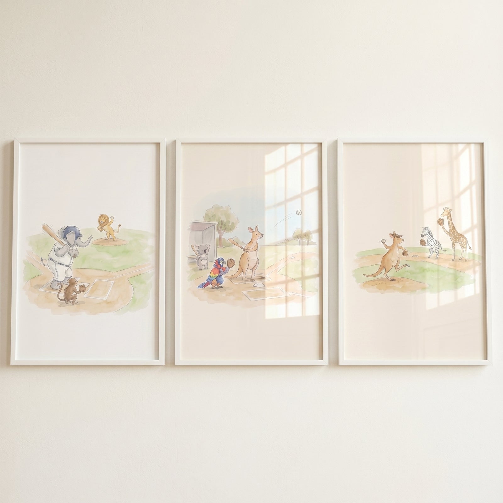 Watercolor baseball playing animals wall art set of 3 features an elephant, kangaroo, and giraffe in white frames.