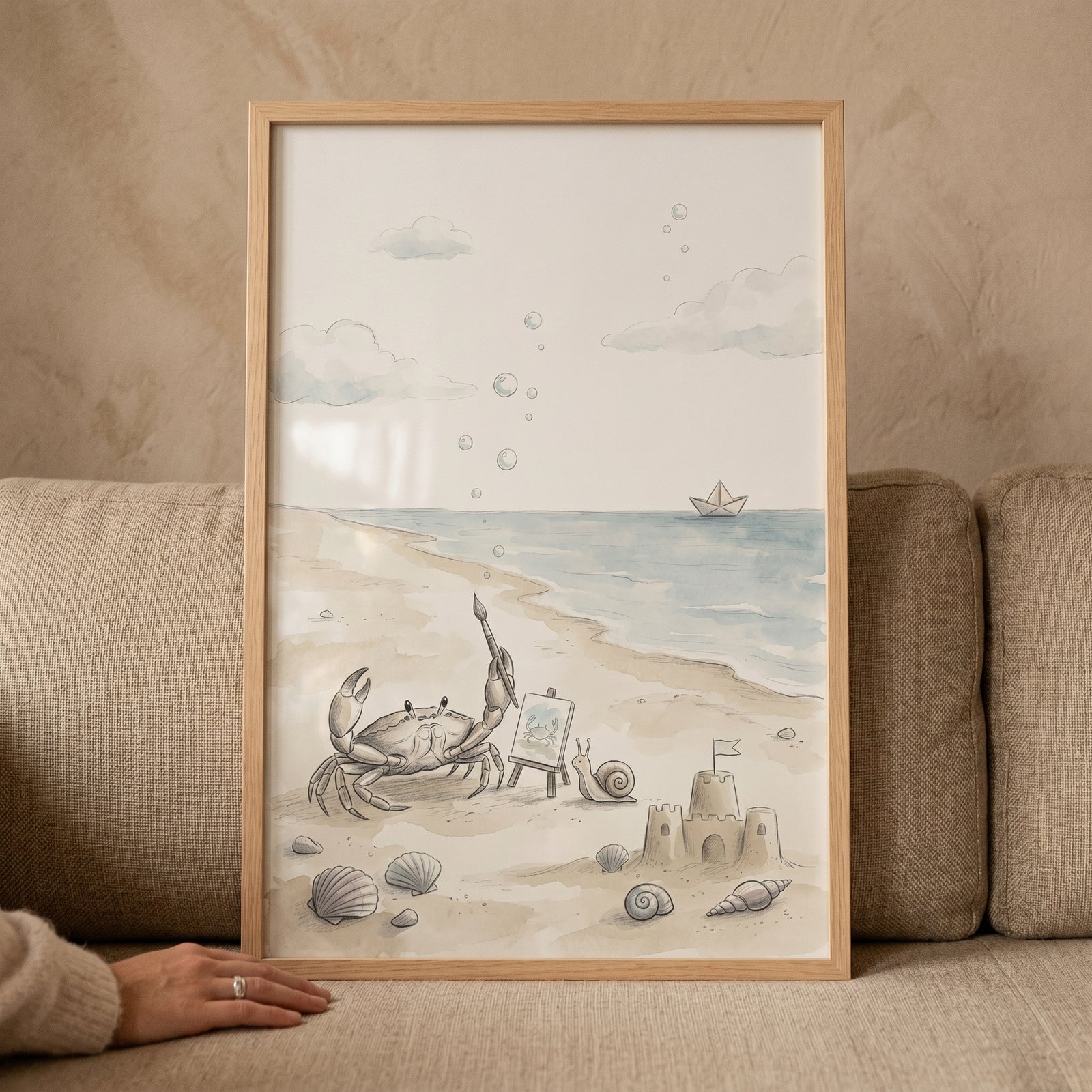 Watercolor beach artist crab wall art shows a crab at an easel, a sandcastle, and a snail on a sandy shore.