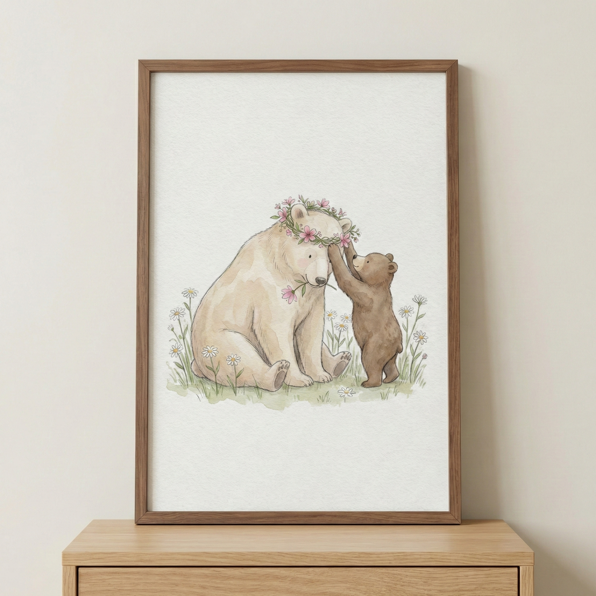 A vertical wooden frame holds a soft watercolor illustration of two bears in a meadow. A large, cream-colored bear sits peacefully, wearing a crown of pink flowers and holding a single blossom in its mouth. A small brown cub stands on its hind legs, reaching up to gently touch the larger bear’s flower wreath. They are surrounded by a patch of green grass dotted with white daisies and delicate pink wildflowers. The framed artwork rests on a light wood surface against a plain, neutral wall.