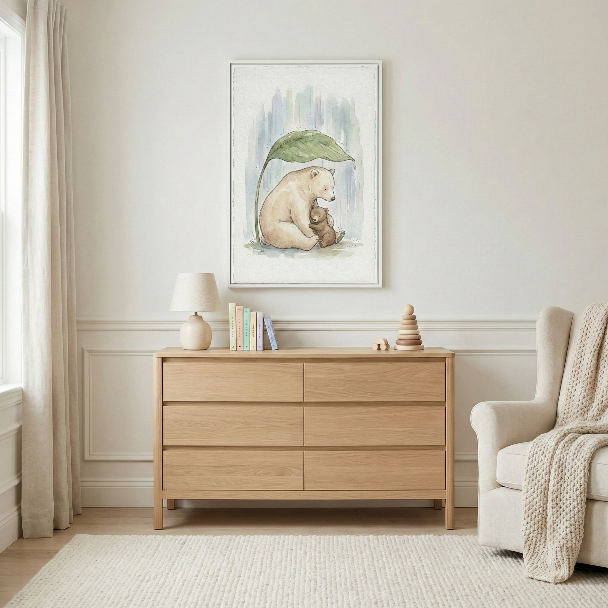 A cozy nursery features a wooden dresser topped with a lamp, a few books, and wooden toys. Above the dresser hangs a charming watercolor painting of a bear sitting with a teddy bear under a large leaf. A soft armchair with a knitted blanket is nearby, and a plush rug covers the floor.
