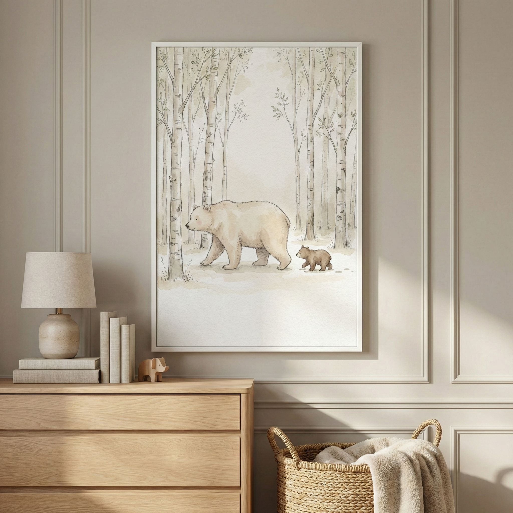 A cozy room features a framed illustration of a bear and cub walking through a forest of slender trees. The artwork hangs above a light wooden dresser adorned with a lamp, books, and a small elephant figurine. A woven basket with a soft blanket is positioned nearby.