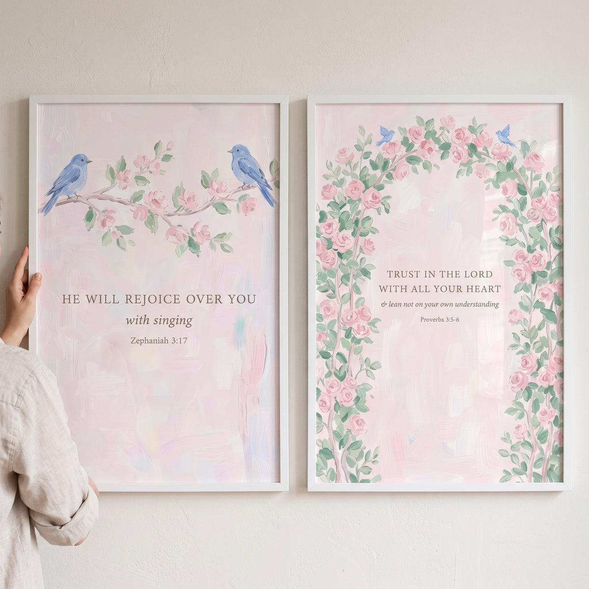 Watercolor blue bird scripture wall art set of 2 with pink floral branches, an arch, and Bible verses in white frames.