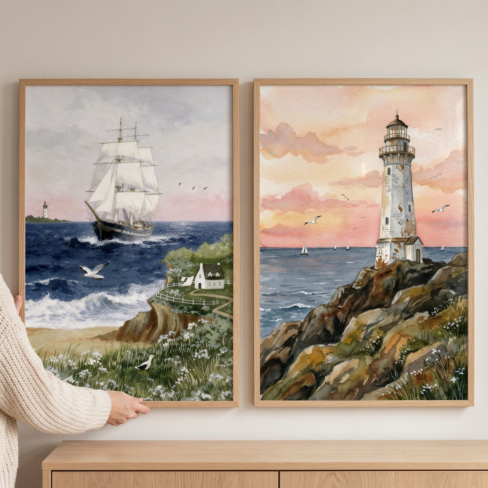 Watercolor blue coastal landscape wall art set of 2 featuring a tall sailing ship and a lighthouse on a rocky shore.