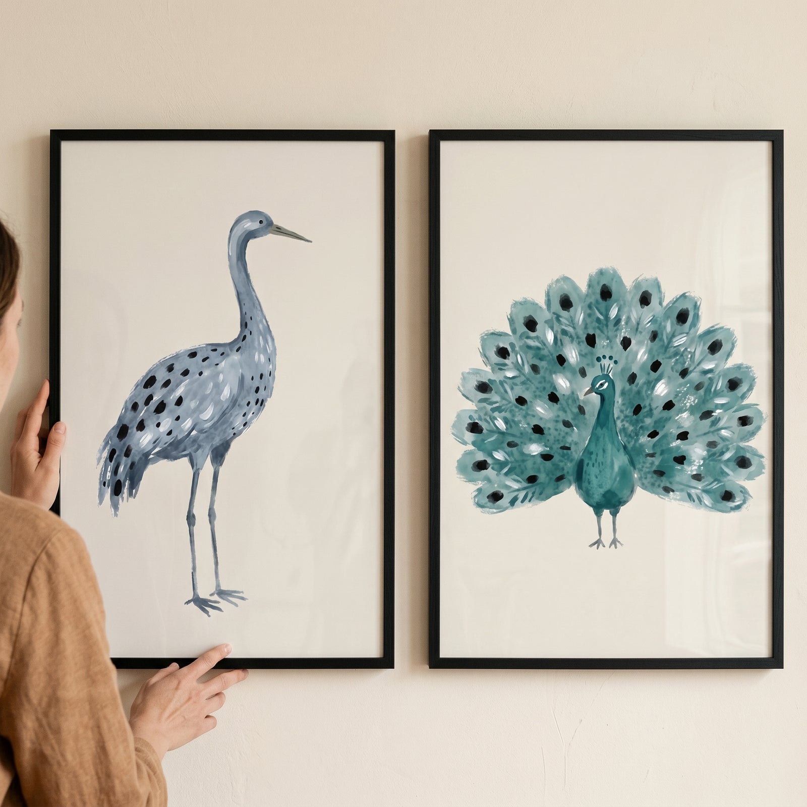 Framed watercolor blue spotted birds wall art set of 2 featuring a crane and a peacock on a neutral wall.