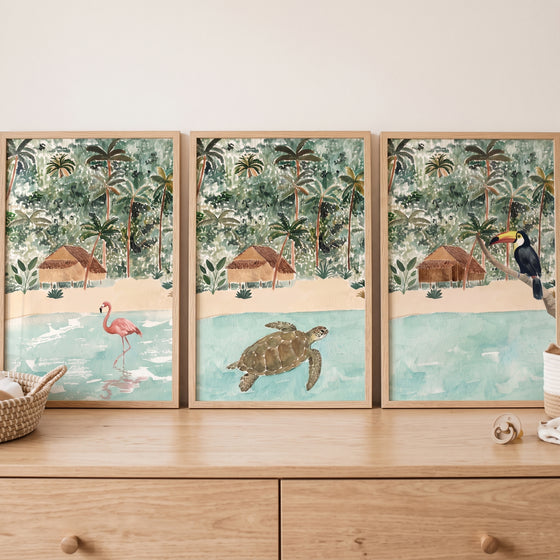Watercolor coastal jungle animals wall art set of 3 featuring a flamingo, sea turtle, and toucan in beach settings.