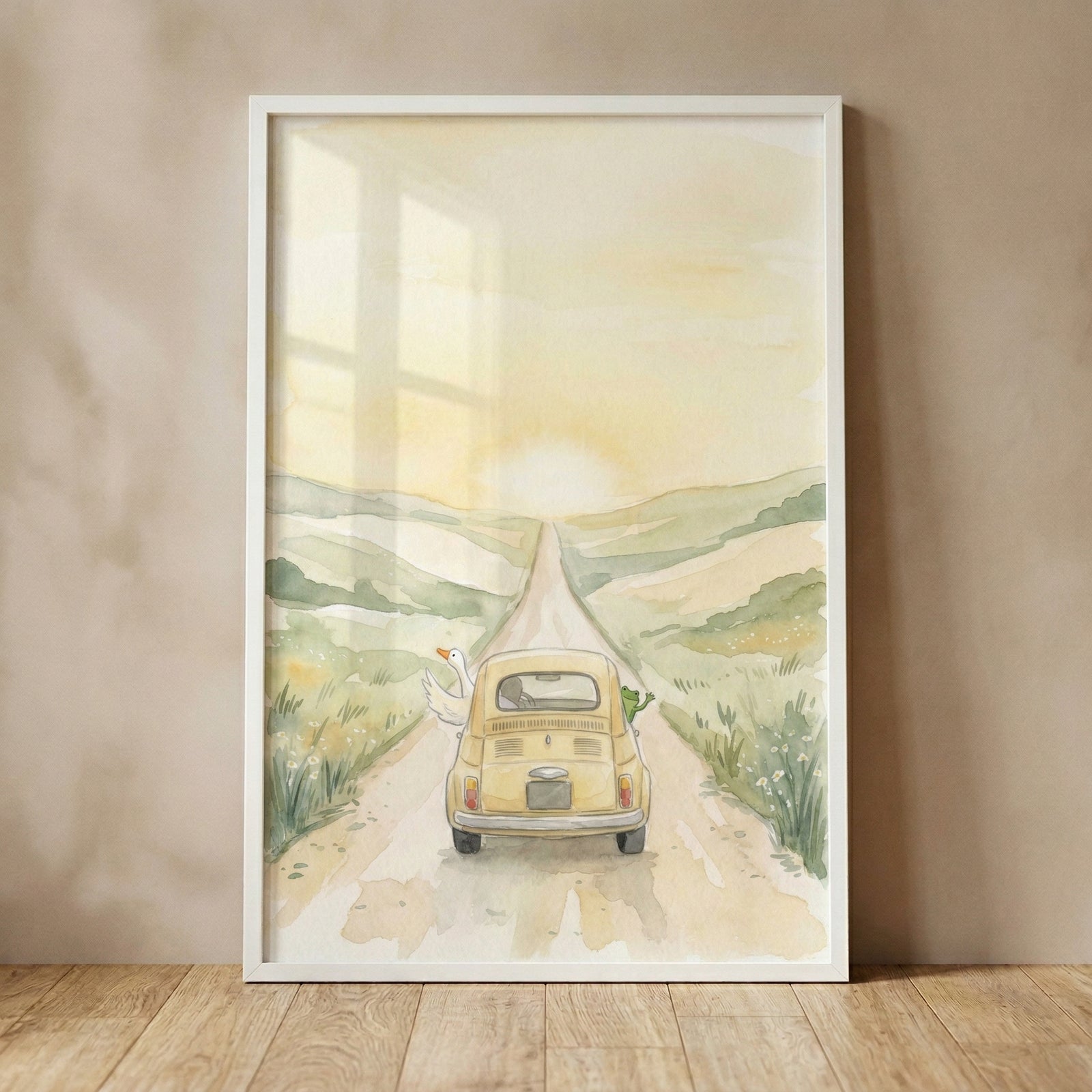 A vertical framed watercolor illustration leans against a plain, neutral wall on a light wood floor. The artwork depicts a whimsical scene with a small, rounded yellow vintage car driving away down a long dirt road towards a bright sun setting behind soft, rolling green hills. 