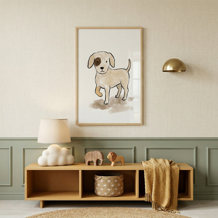 A framed art piece featuring a simple, hand-drawn style illustration of a light-brown puppy with a dark spot over one eye hangs on a textured cream-colored wall. The wall has a sage-green wainscoting panel at the bottom.
