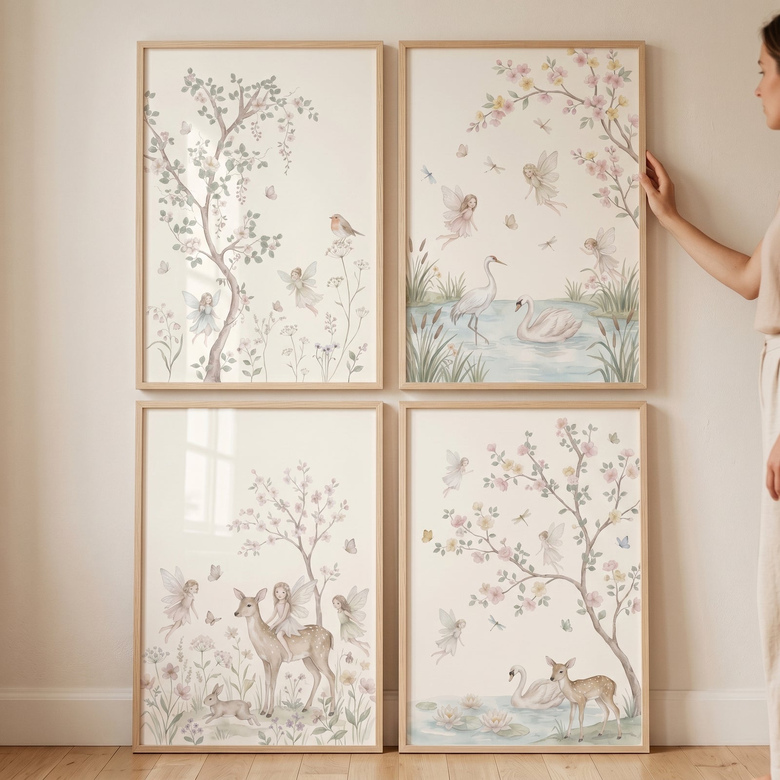 Watercolor flowering branch fairies wall art set of 4 in light wood frames depicts deer and swans in soft pastels.