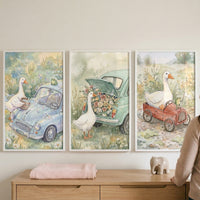 This set of three framed wall art pieces features a whimsical series of watercolor illustrations depicting white geese and vintage-style vehicles. The scenes are rendered in soft, pastel tones, creating a gentle and charming atmosphere suitable for a nursery or child's room.
