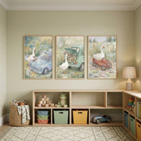 A serene and light-filled child's playroom features a row of three framed watercolor-style illustrations hung above a low wooden storage unit. The walls are painted a soft sage green, creating a peaceful atmosphere.
