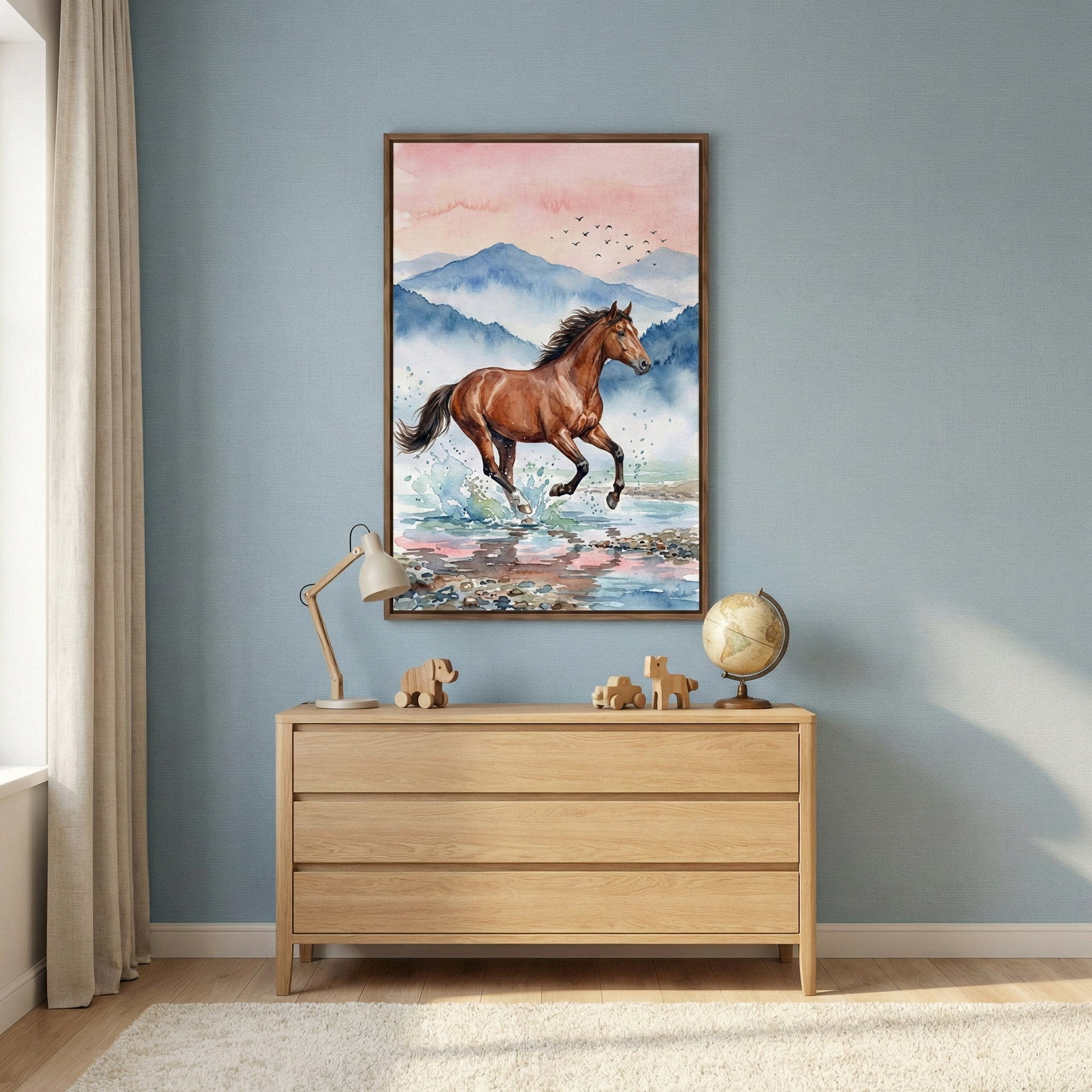 A framed watercolor-style artwork of a brown horse galloping through splashing water hangs on a light blue wall. The artwork features distant blue mountains and a soft pink sky with small birds. Below it, a light-colored wooden three-drawer dresser holds a small desk lamp, two minimalist wooden animal toys, and a globe on a stand. To the left, a neutral-toned curtain is partially visible. The scene is set above a white textured rug in a bright, modern room.
