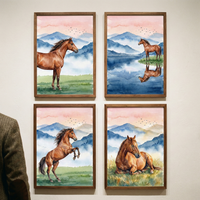 Four framed watercolor-style artworks hang in a grid on a wall. Each features a brown horse against a backdrop of blue mountains and a pink sky with small birds. Top left: a horse stands in a green field. Top right: a horse stands by a lake with its reflection. Bottom left: a horse rears up. Bottom right: a horse rests in the grass. The pieces are in wooden frames. A portion of a person's textured brown jacket is visible on the far left side of the frame.