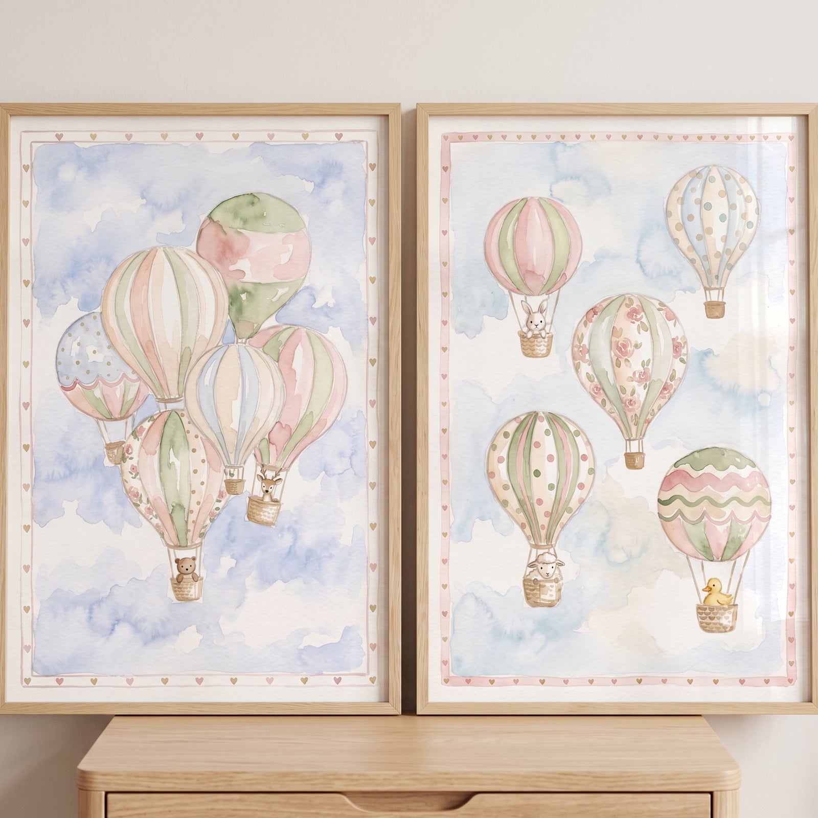 Watercolor hot air balloon wall art set of 2 featuring animals in pastel balloons drifting through soft blue clouds.