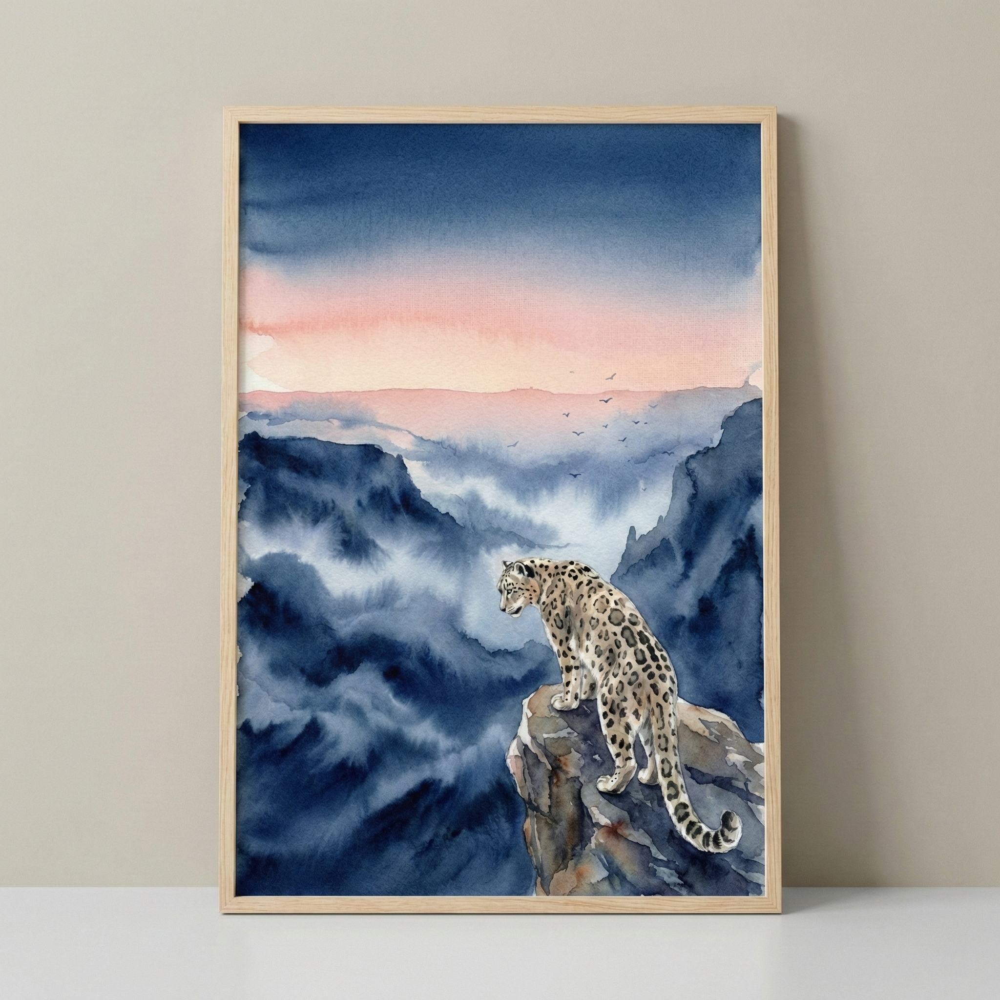 A framed watercolor painting depicts a snow leopard standing on a rocky cliff, overlooking a misty, mountainous landscape. The sky is painted in soft hues of pink and blue, with a few birds silhouetted in the distance.