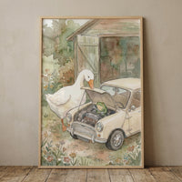 A framed watercolor-style illustration depicts a whimsical and charming scene in a rustic garden. In the center, a large white goose and a small green frog are busily repairing a tiny, cream-colored vintage compact car. 
