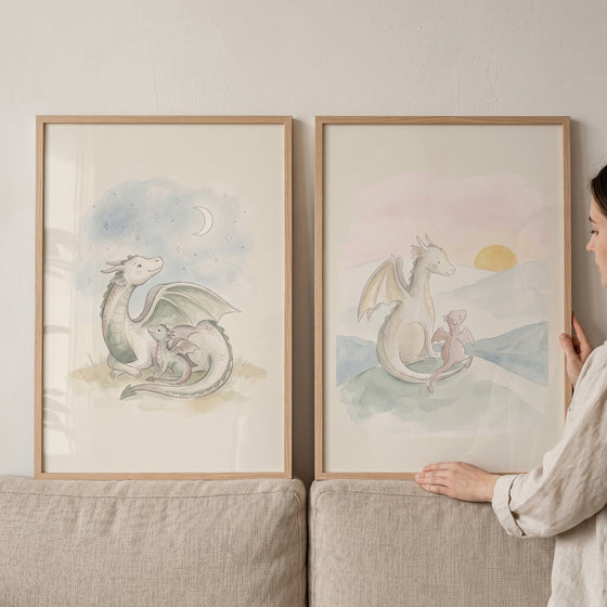 Watercolor pastel dragon duo wall art set of 2 with parent and baby dragons under a crescent moon and a rising sun.