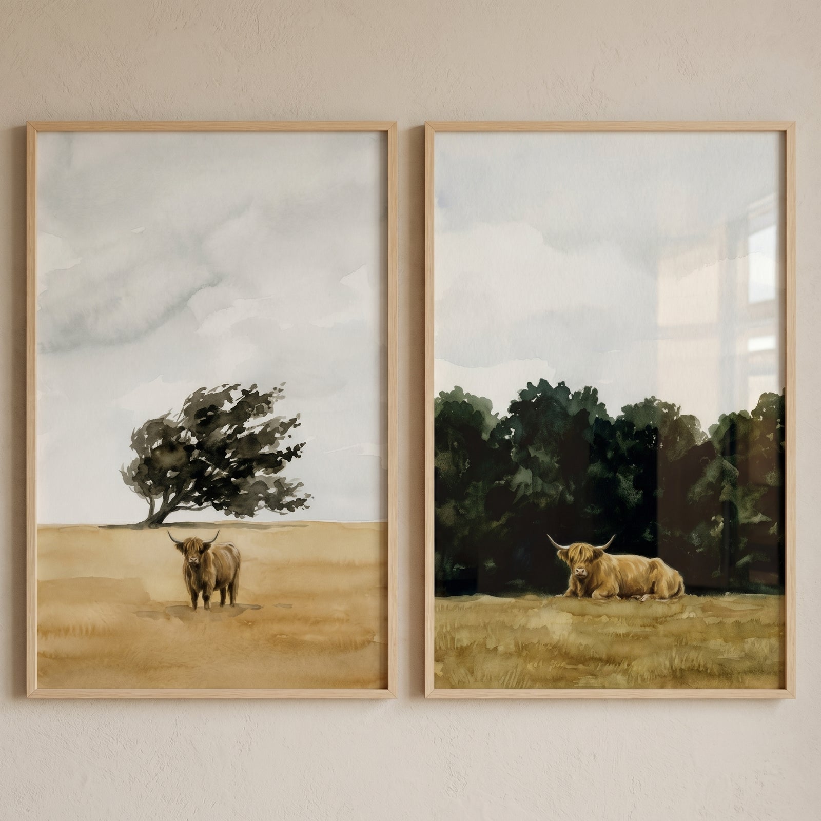 Watercolor rustic highland cow wall art set of 2 features a cow by a lone tree and another cow resting near a forest.