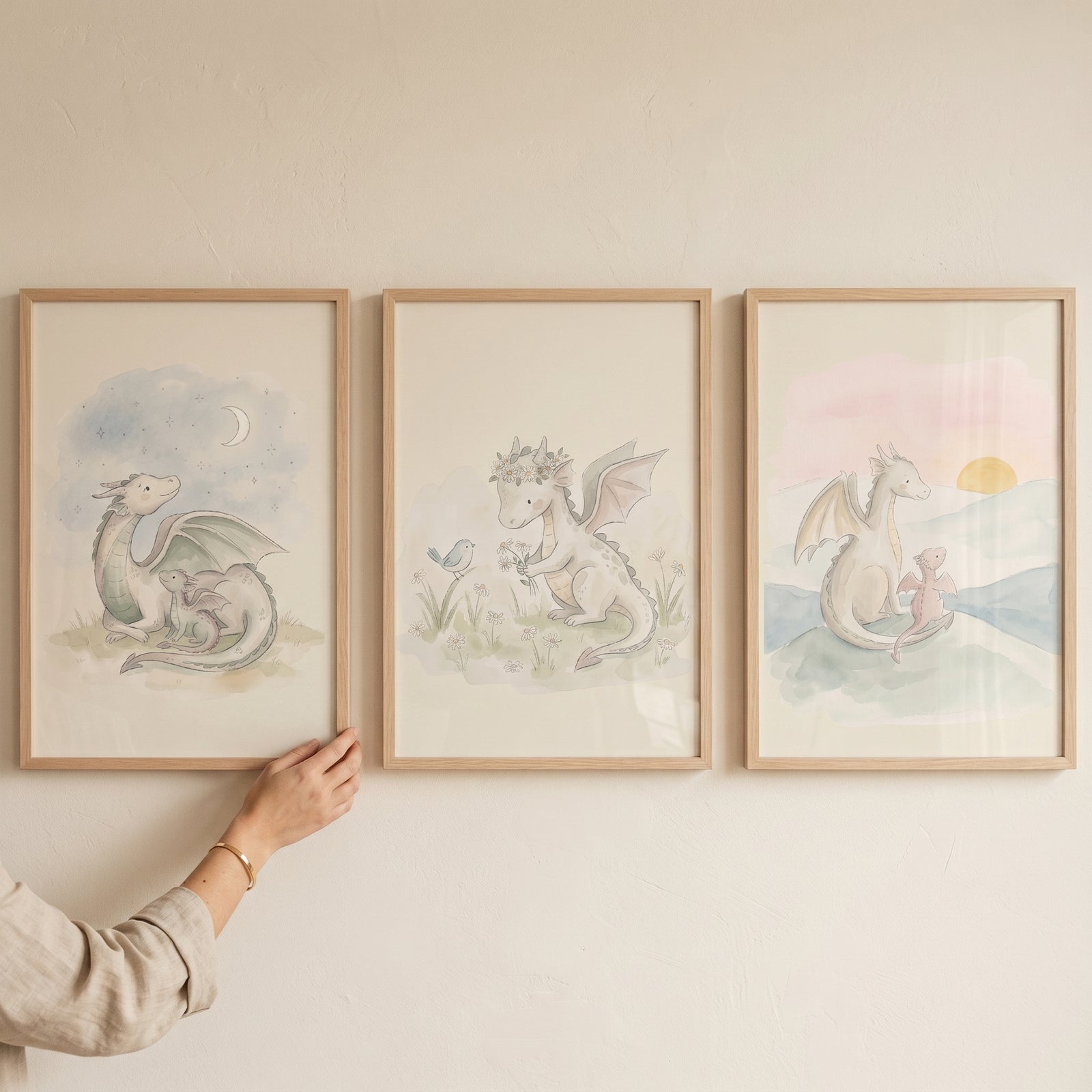 Watercolor sage baby dragon wall art set of 3 featuring gentle dragons under a moon, in a field with a bird, and at sunset.