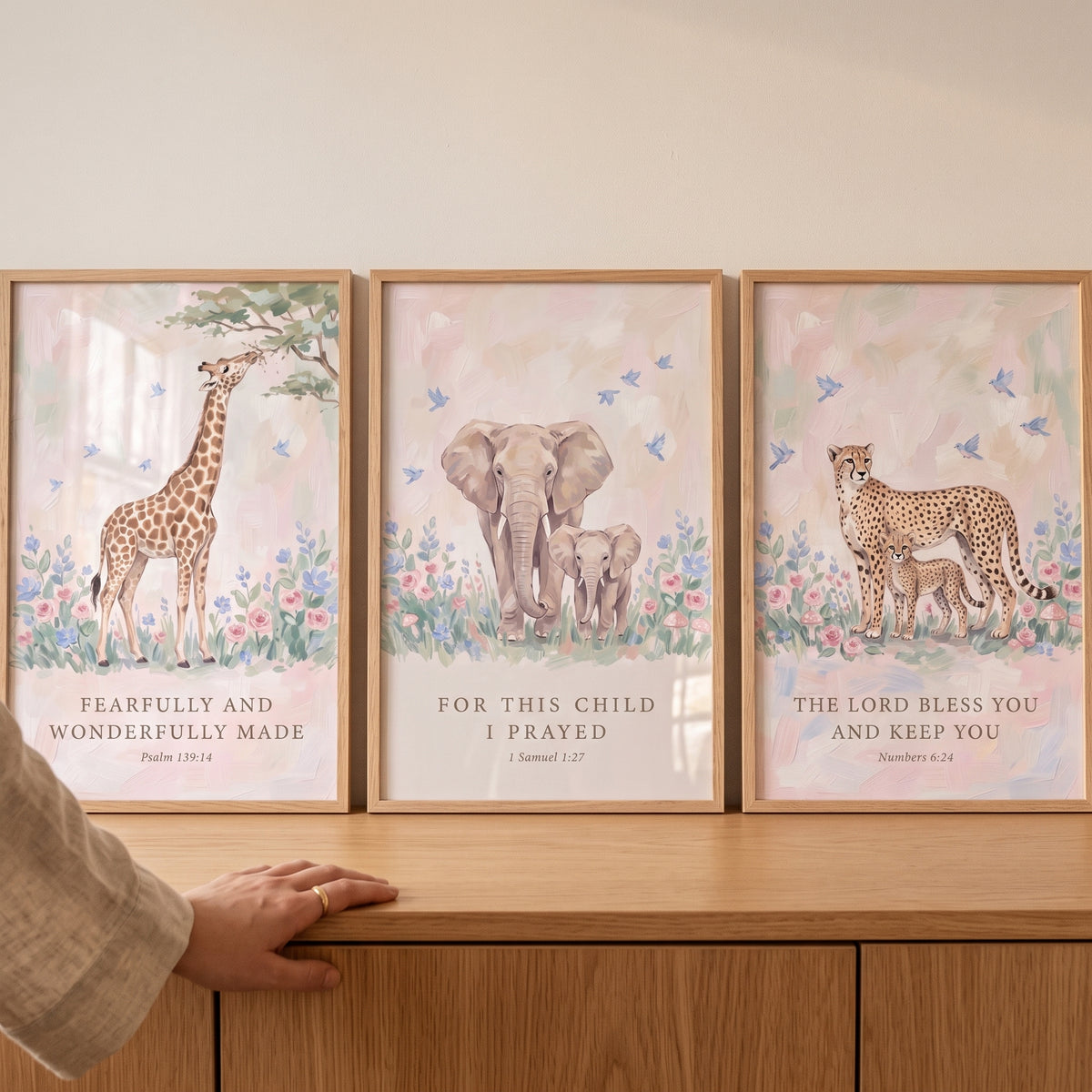 Watercolor scripture safari animals wall art set of 3 featuring a giraffe, elephants, and cheetahs on a wood dresser.