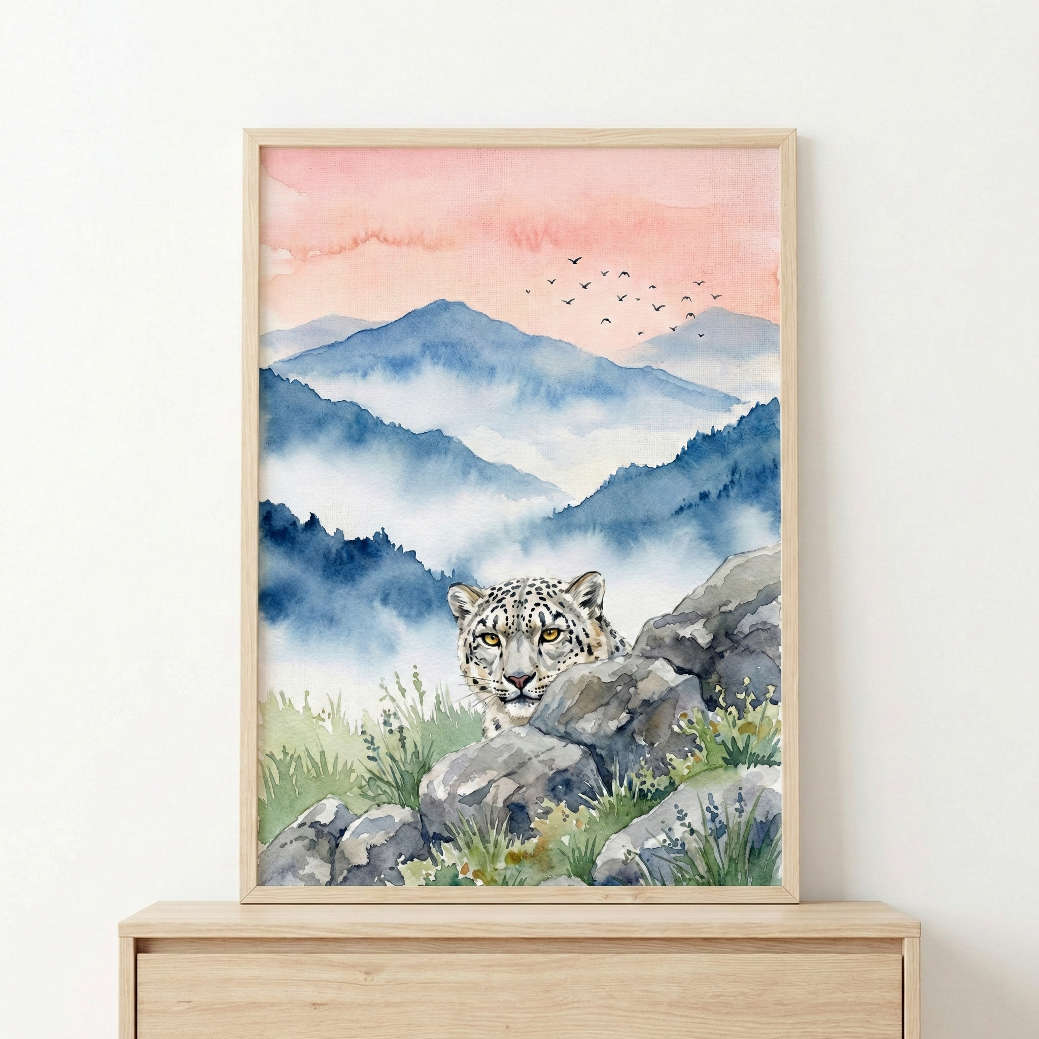 A framed watercolor painting depicts a snow leopard peeking over rocks in a misty mountain landscape, with a pink and blue sky and a flock of birds in the distance.