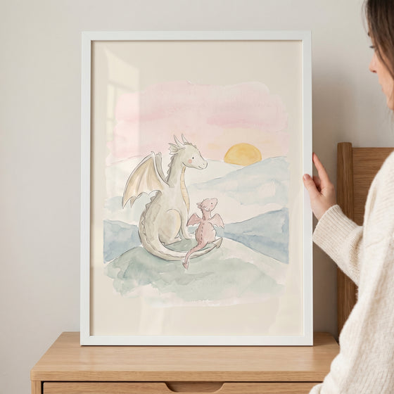 Framed watercolor sunset dragon wall art showing two dragons sitting on a hill watching the sun set over mountains.