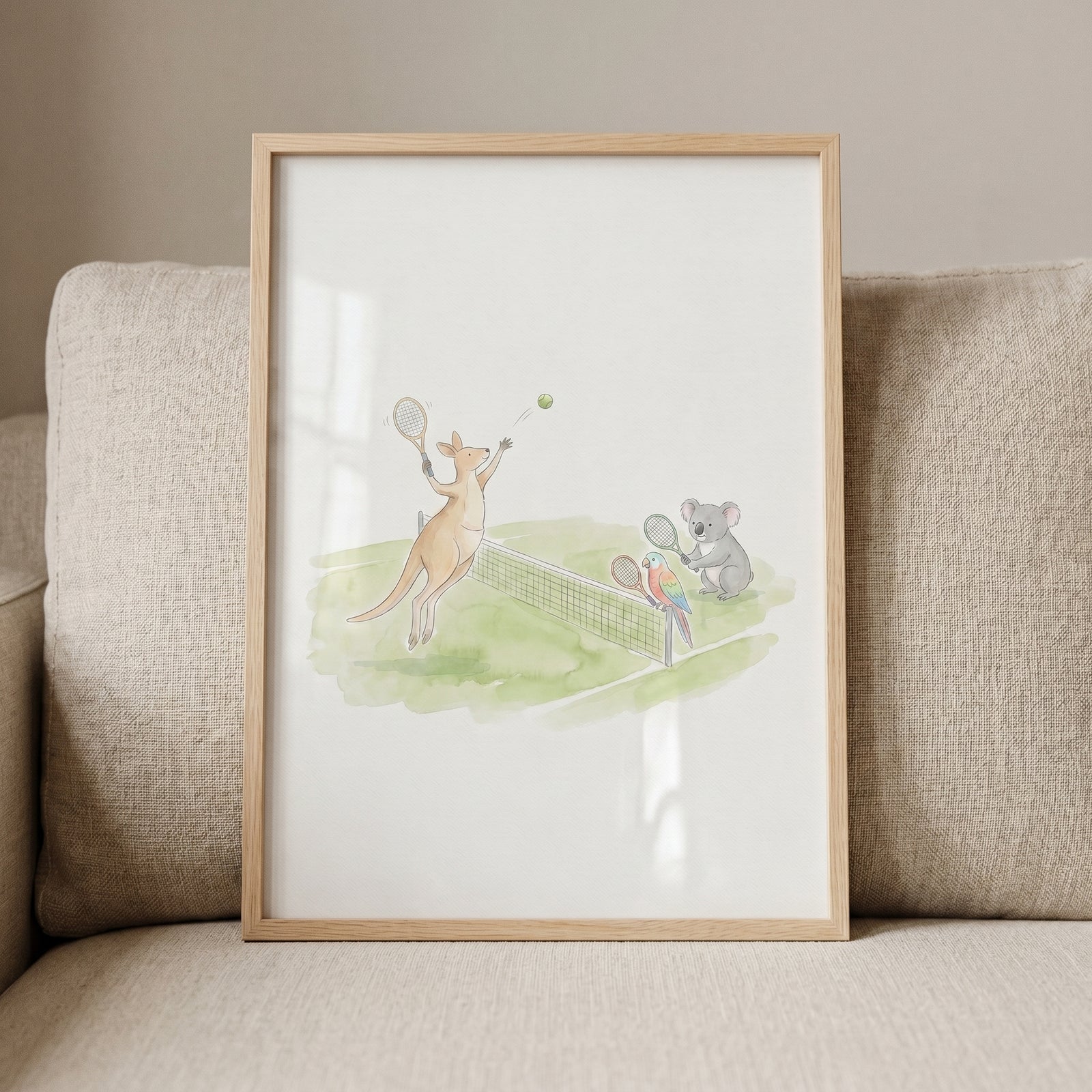 Kangaroo, koala, and parrot play on a court in this watercolor tennis animals wall art framed on a beige sofa.