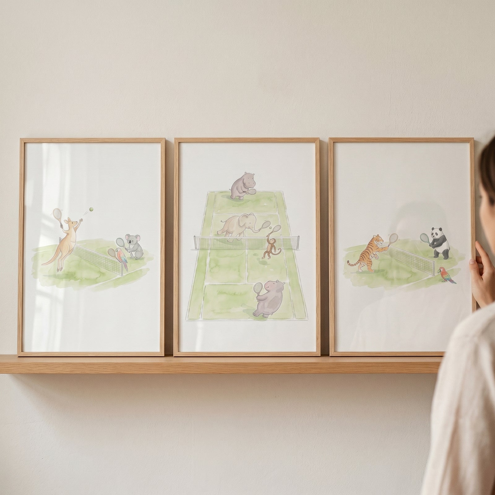 Watercolor tennis playing animals wall art set of 3 with a kangaroo, koala, elephant, hippo, tiger, and panda.