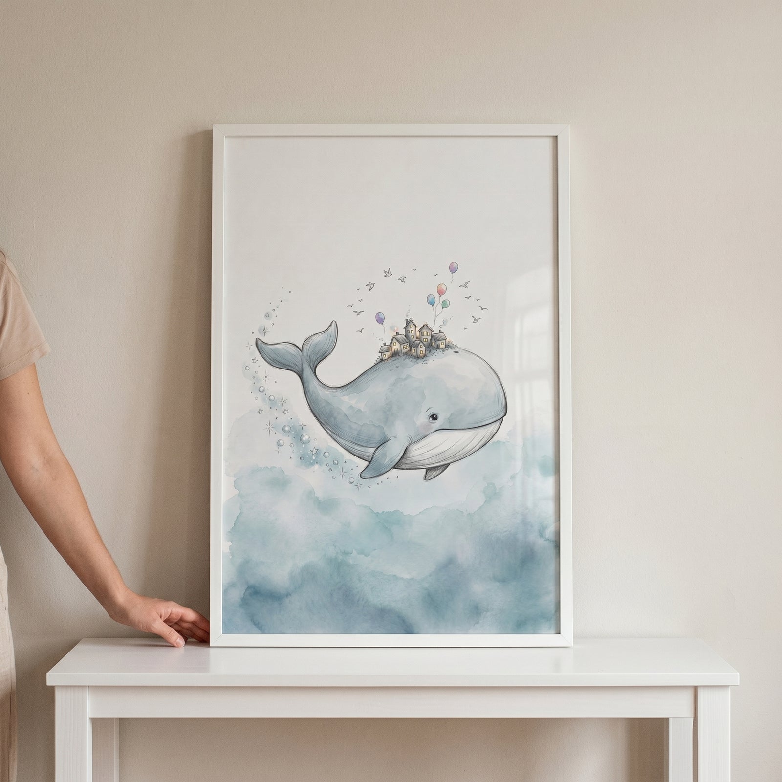 Framed watercolor tiny village whale wall art shows a blue whale carrying houses and balloons through blue clouds.