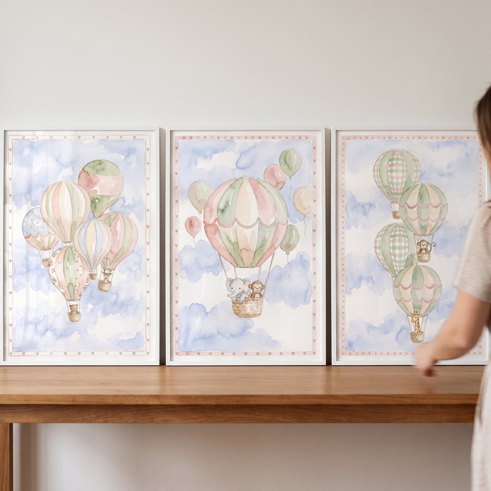 Watercolor whimsical safari balloon wall art set of 3 featuring animals in hot air balloons against a soft blue sky.
