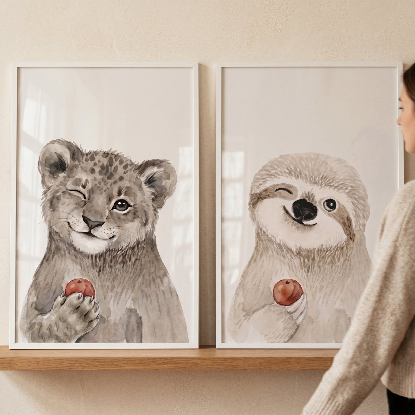 Watercolor winking apple animals wall art set of 2 featuring a leopard cub and sloth displayed on a wooden shelf.