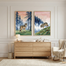A modern nursery scene features two large, vertically oriented, wood-framed illustrations hanging on a white wall with decorative molding. The left piece of art shows a brown wolf standing in a grassy meadow surrounded by tall, misty blue pine trees under a soft pink and orange sky. The right piece shows a wolf walking down a green grassy hill, with similar misty blue trees and a flock of birds in the distance against a pink sky.