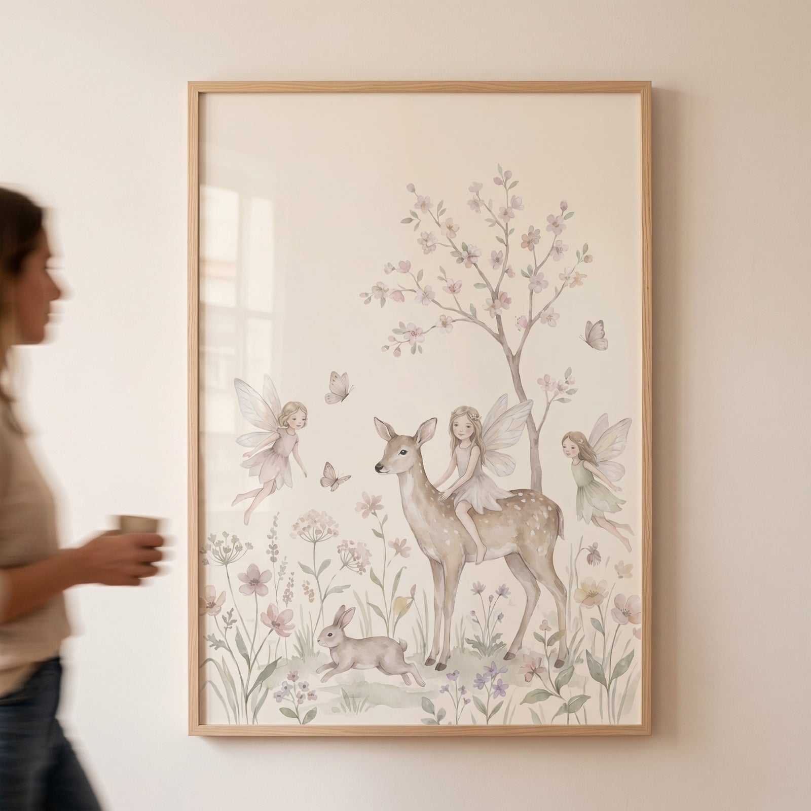 Framed watercolor woodland fairy deer wall art depicting winged fairies, a deer, and a rabbit in a flowered meadow.