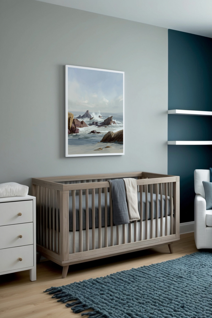 Modern nursery featuring gray and deep blue accents, a minimalist wooden crib, and striking coastal artwork of waves crashing against rocky shores, creating a soothing yet dynamic atmosphere.