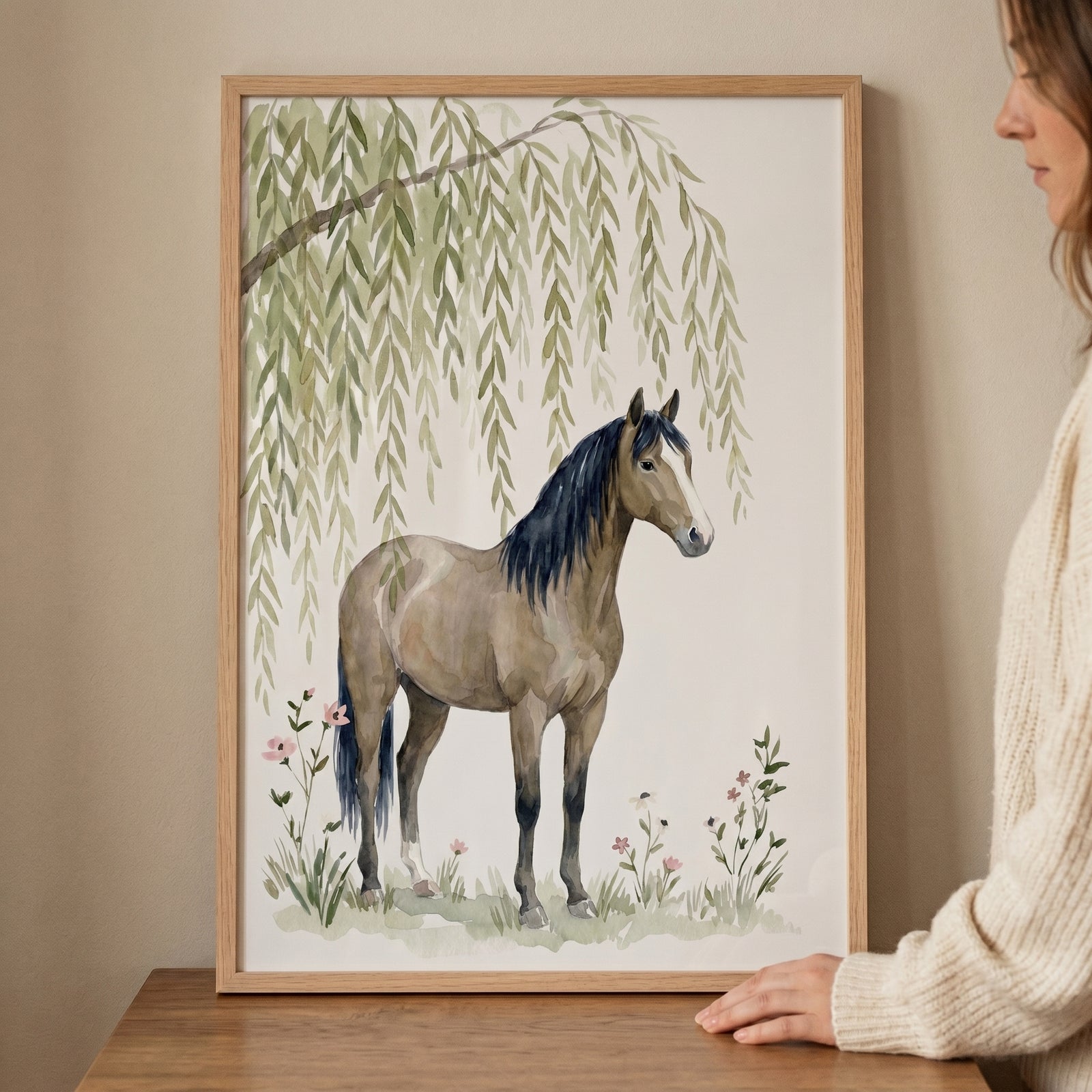 Weeping willow brown horse wall art in a wood frame showing a horse under willow leaves, held by a woman at a table.