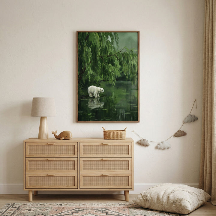 Minimal neutral nursery with wooden dresser and soft decor featuring a framed painting of a polar bear standing by a still green pond beneath drooping tree branches. The artwork adds a calm nature inspired focal point that brings a quiet woodland feel to the space.