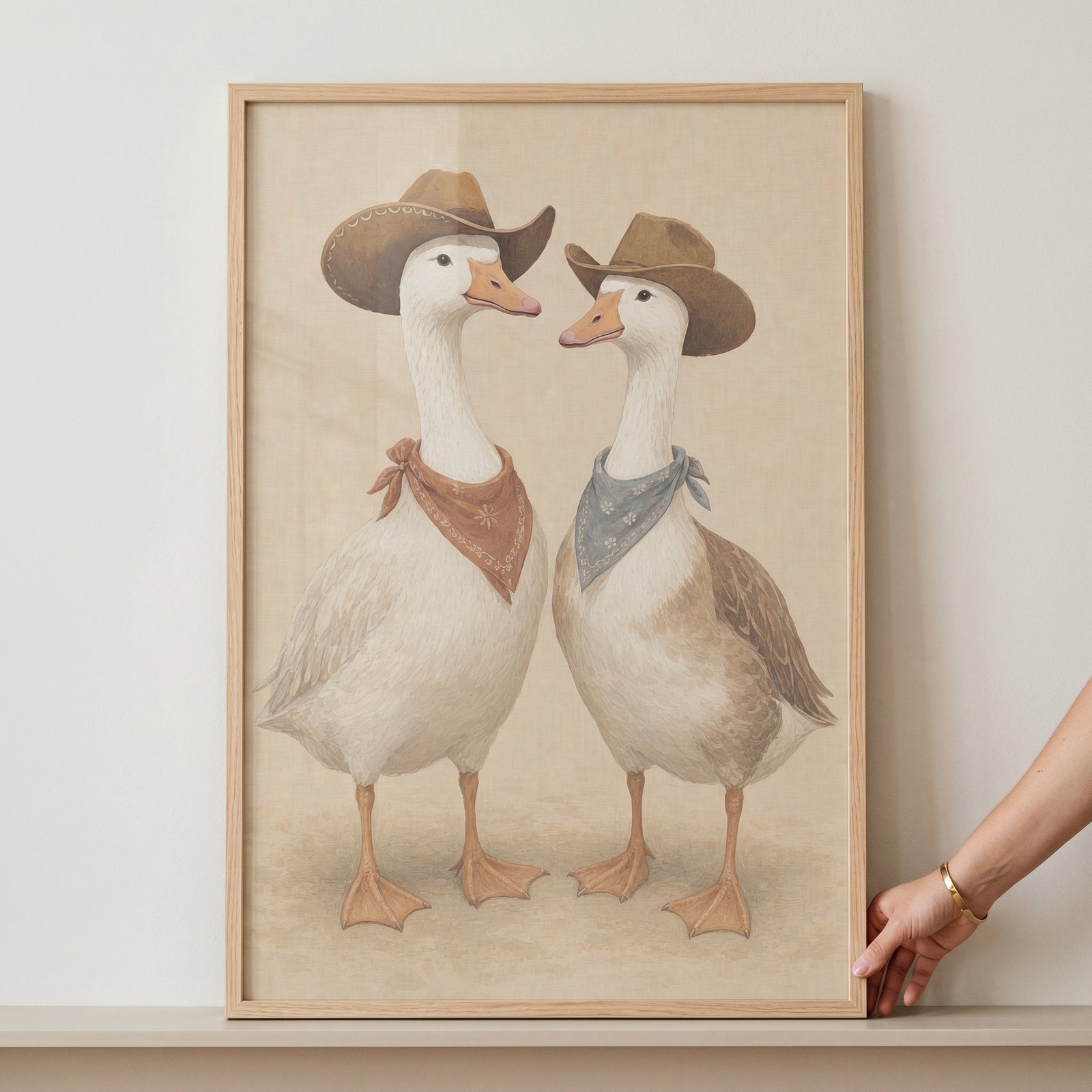 Western cowboy duo geese wall art featuring two geese in brown hats and bandanas, presented in a light wood frame.
