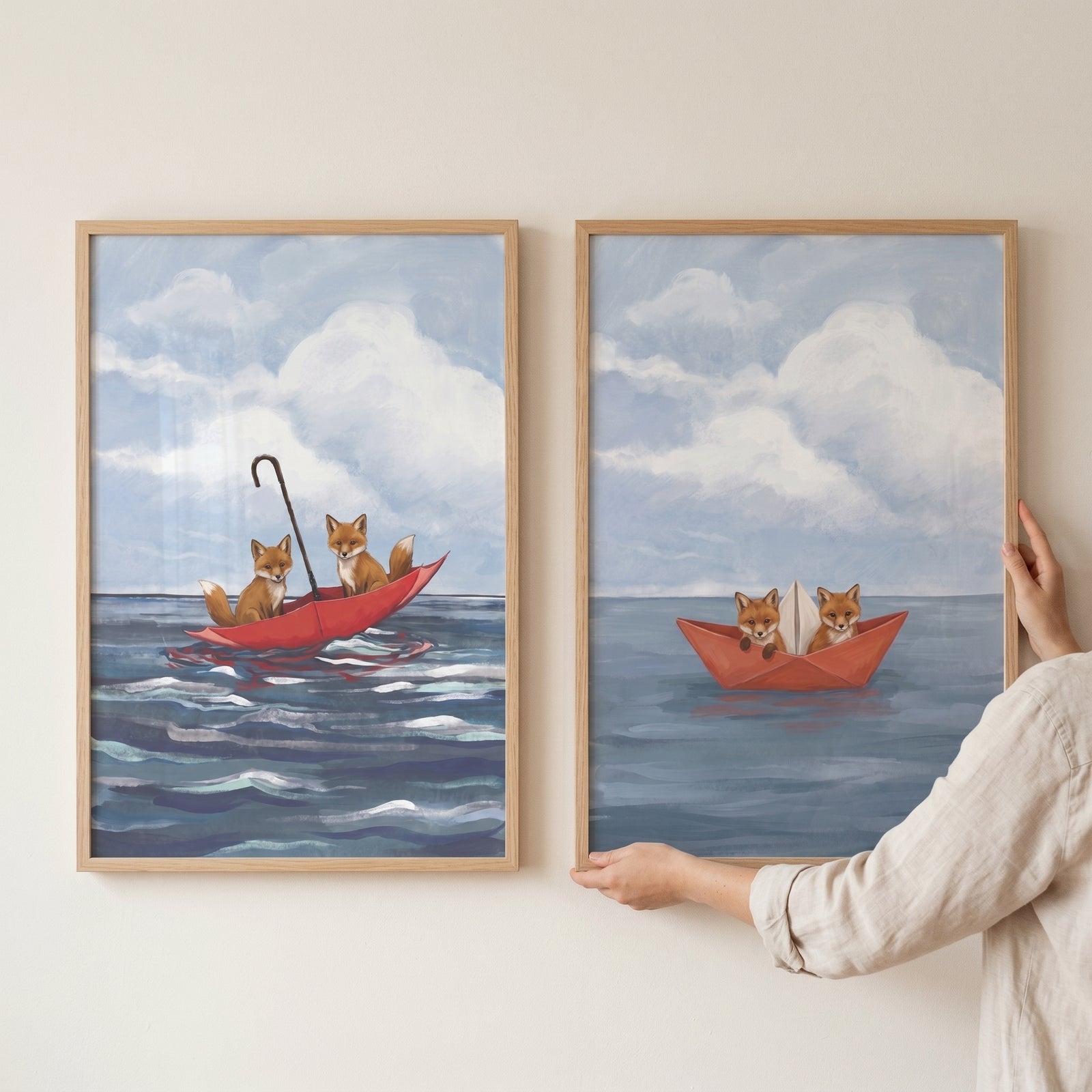 Two foxes in an umbrella and two in a paper boat in this whimsical blue ocean foxes wall art set of 2.